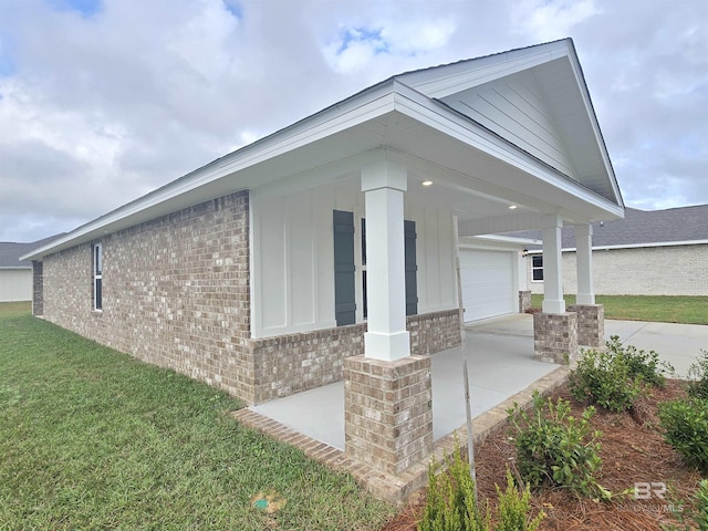 view of property exterior featuring an attached garage, a lawn, concrete driveway, and brick siding