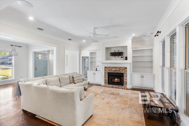 living room with hardwood / wood-style flooring, a brick fireplace, ceiling fan, and ornamental molding