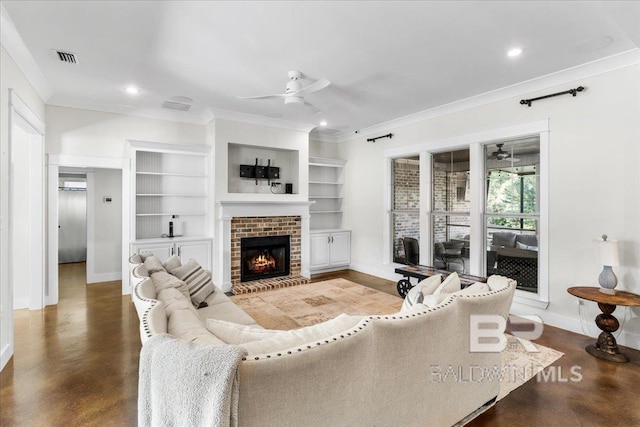 living room featuring built in shelves, ceiling fan, crown molding, and a brick fireplace