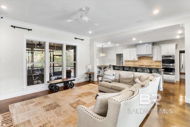 living room featuring ceiling fan, crown molding, and concrete floors