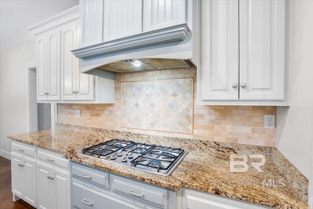 kitchen with custom range hood, backsplash, white cabinetry, and stainless steel gas cooktop