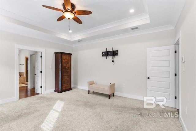 interior space with carpet flooring, a tray ceiling, ceiling fan, and crown molding