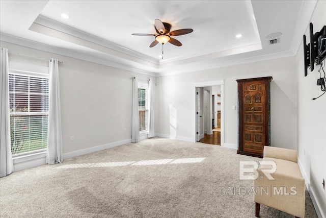 interior space with a tray ceiling, ceiling fan, and carpet flooring