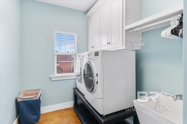 laundry area featuring washer and clothes dryer and cabinets