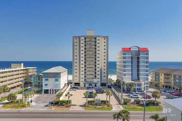 view of property with uncovered parking, a view of city, and a water view