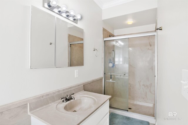 full bath featuring vanity, a stall shower, and crown molding