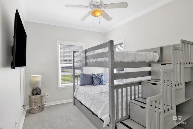 carpeted bedroom with baseboards, crown molding, and ceiling fan