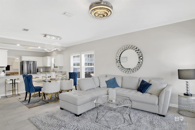 living room featuring baseboards, visible vents, and ornamental molding