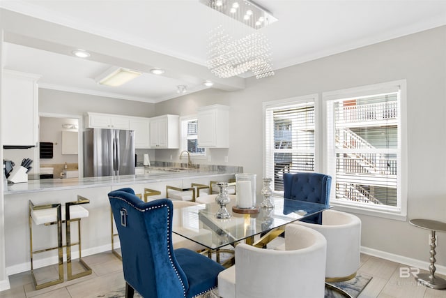 dining area with an inviting chandelier, crown molding, and baseboards