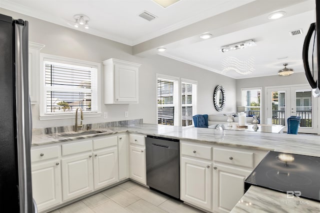 kitchen featuring a sink, freestanding refrigerator, dishwashing machine, visible vents, and ornamental molding