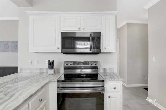 kitchen featuring crown molding, baseboards, white cabinets, light stone countertops, and appliances with stainless steel finishes