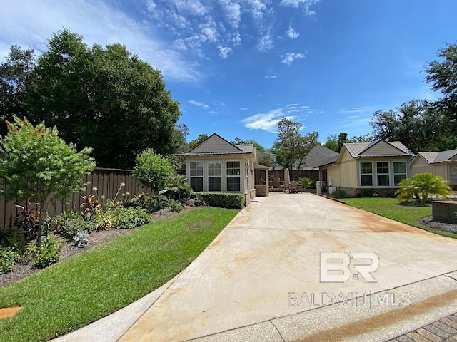 view of front facade featuring a front yard, fence, and driveway