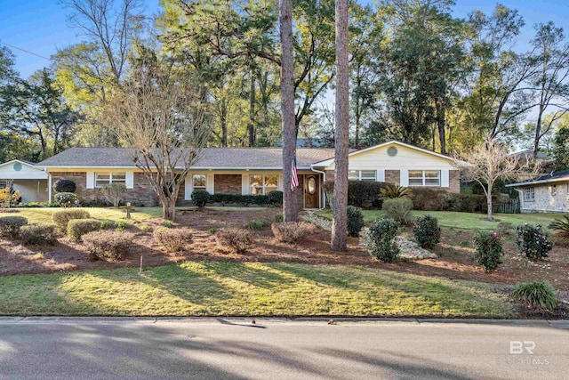 single story home featuring a front yard and brick siding