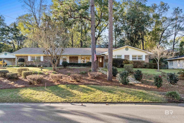 ranch-style house featuring brick siding and a front yard