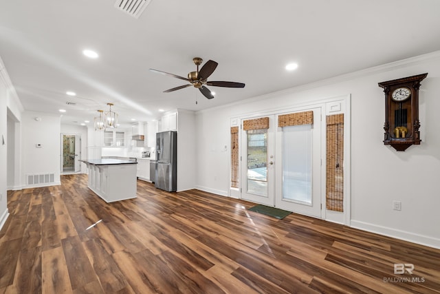 kitchen with stainless steel fridge, visible vents, a kitchen island, hanging light fixtures, and white cabinetry