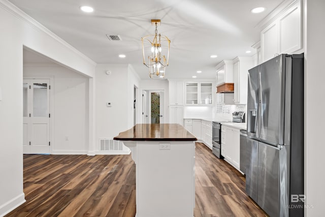 kitchen featuring appliances with stainless steel finishes, a center island, glass insert cabinets, and white cabinets