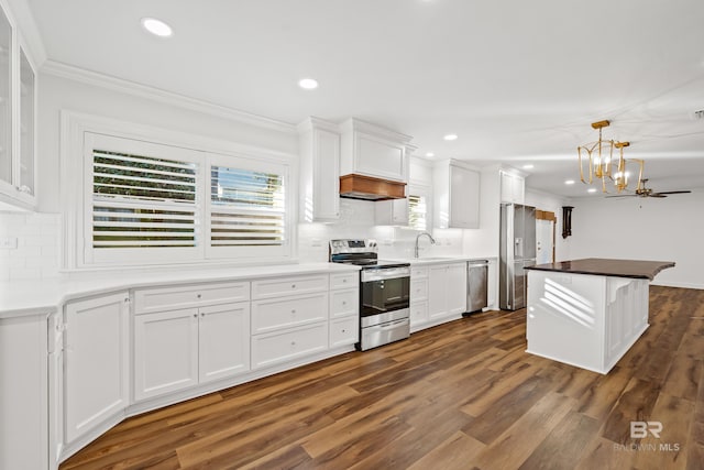 kitchen with stainless steel appliances, pendant lighting, white cabinets, and a sink