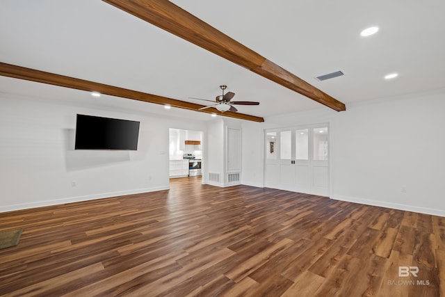 unfurnished living room with visible vents, beamed ceiling, baseboards, and wood finished floors