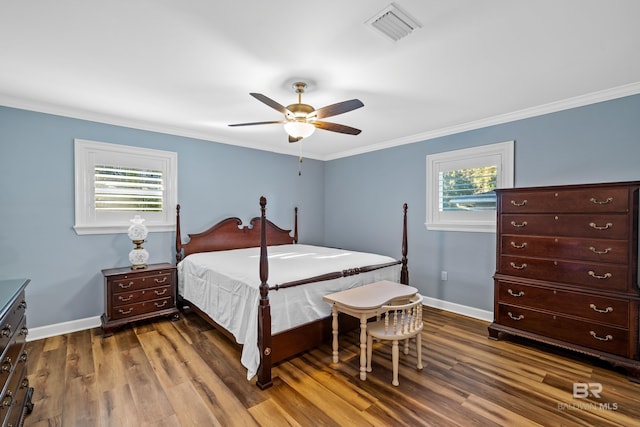 bedroom featuring baseboards, visible vents, dark wood-style flooring, and ornamental molding