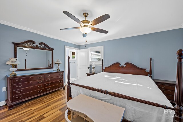 bedroom featuring light wood finished floors, ornamental molding, and a ceiling fan