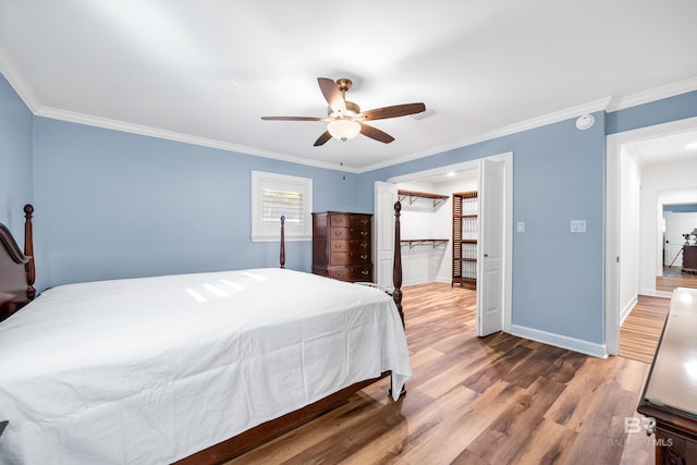 bedroom with crown molding, visible vents, ceiling fan, wood finished floors, and baseboards