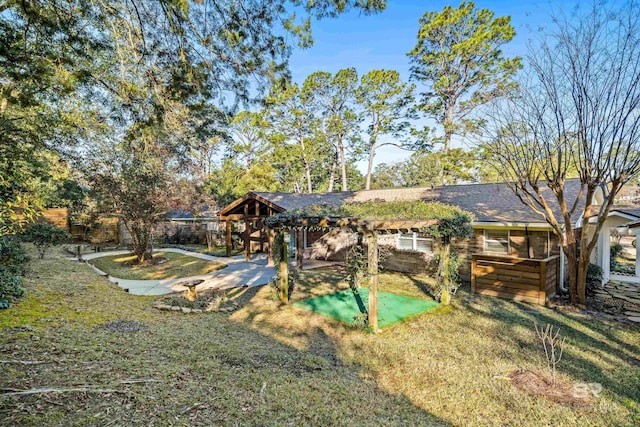 exterior space with roof with shingles, a lawn, fence, and a pergola