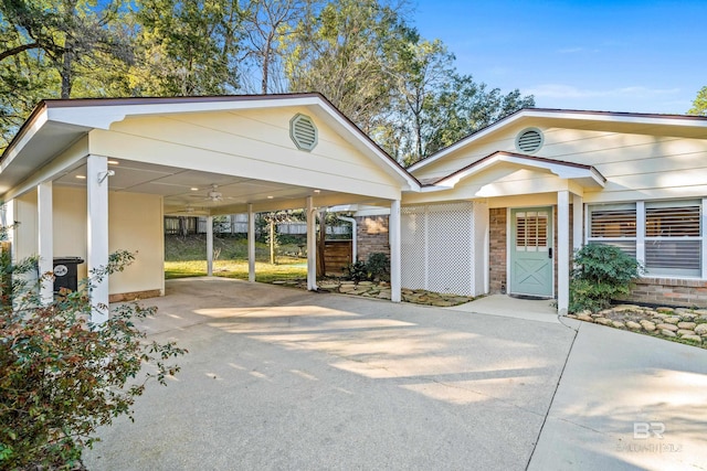 exterior space with driveway, an attached carport, and brick siding