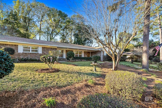 single story home featuring a front lawn and brick siding