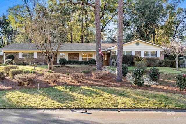 single story home featuring brick siding and a front yard