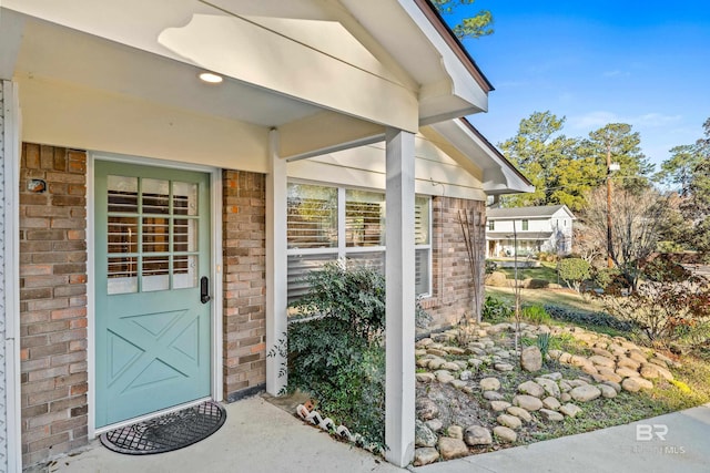 entrance to property featuring brick siding