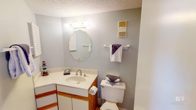 bathroom featuring toilet, vanity, and a textured ceiling