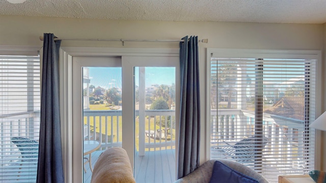 doorway to outside with a textured ceiling