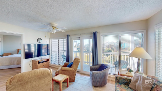 living room with ceiling fan and a textured ceiling