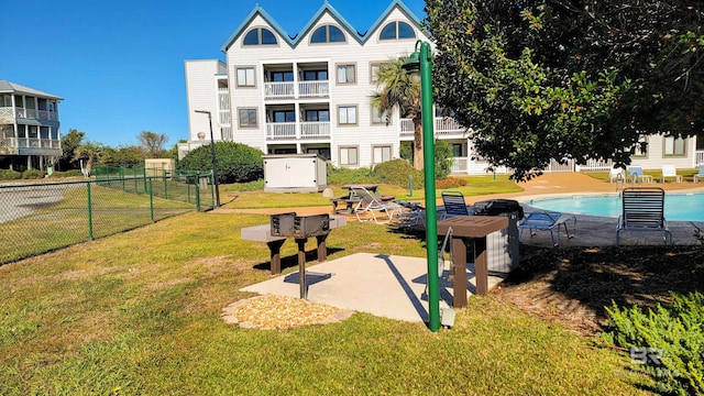 view of community with a lawn and a swimming pool