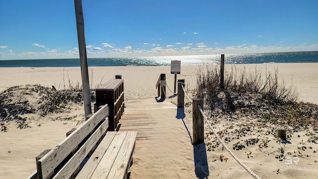 dock area with a water view and a beach view