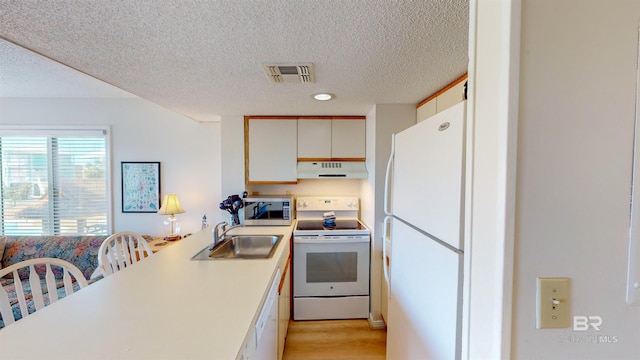 kitchen with white appliances, white cabinets, a textured ceiling, light hardwood / wood-style floors, and sink