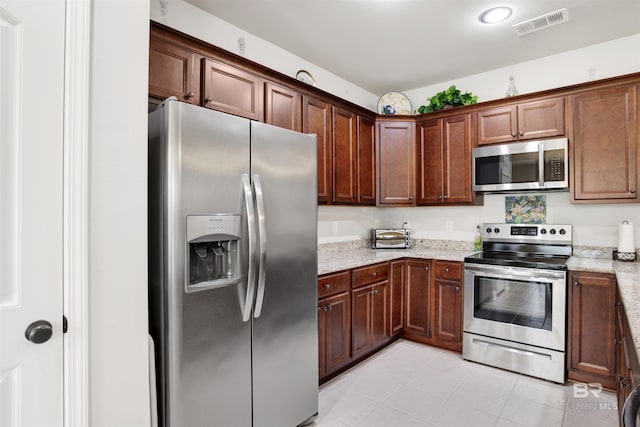 21105 Zinfandel Ln, Silverhill, AL 36576 - kitchen with light tile patterned floors, visible vents, light stone counters, and appliances with stainless steel finishes