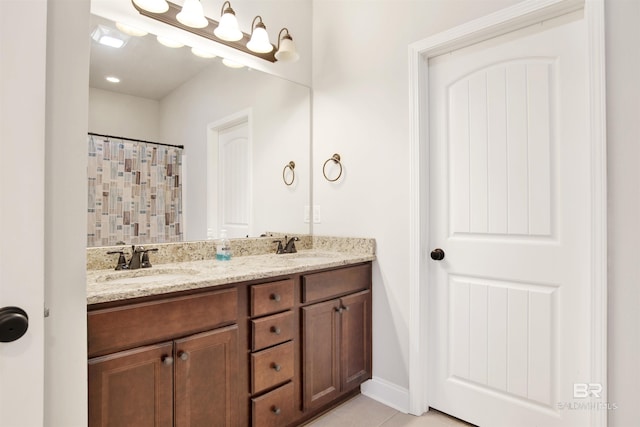 21105 Zinfandel Ln, Silverhill, AL 36576 - bathroom featuring tile patterned flooring, double vanity, baseboards, and a sink