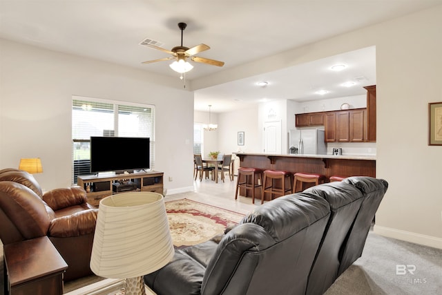 21105 Zinfandel Ln, Silverhill, AL 36576 - living room featuring visible vents, baseboards, light colored carpet, and ceiling fan with notable chandelier