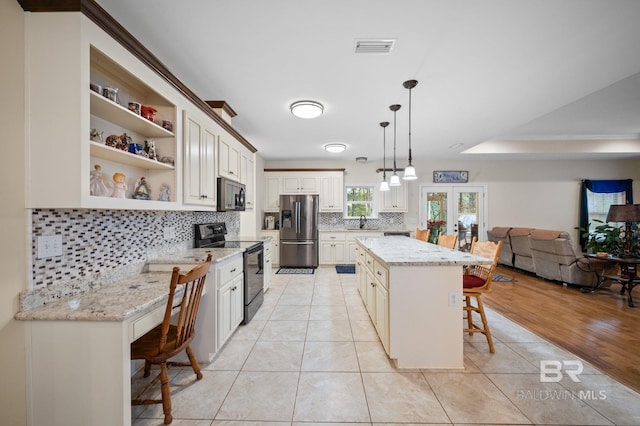 kitchen featuring a center island, hanging light fixtures, a kitchen bar, appliances with stainless steel finishes, and light tile patterned flooring