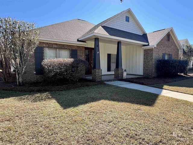 view of front of home featuring a shingled roof and a front yard