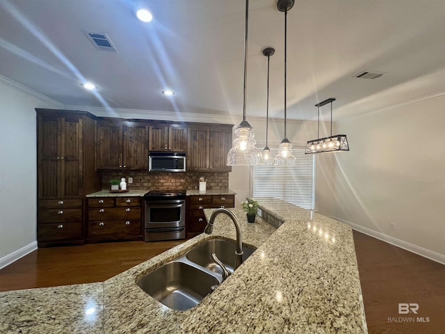 kitchen with pendant lighting, visible vents, appliances with stainless steel finishes, a sink, and light stone countertops