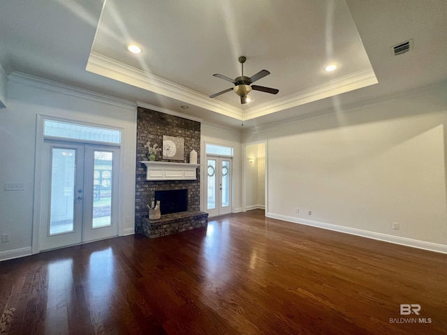 unfurnished living room featuring a wealth of natural light, french doors, a raised ceiling, and visible vents