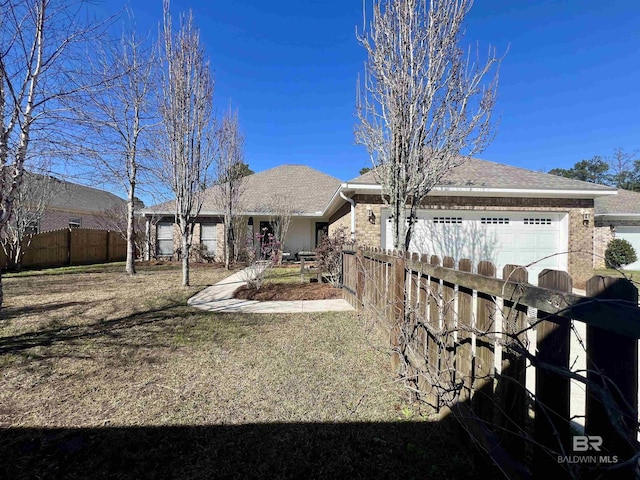 view of front of house with a garage, a shingled roof, fence, and a front yard