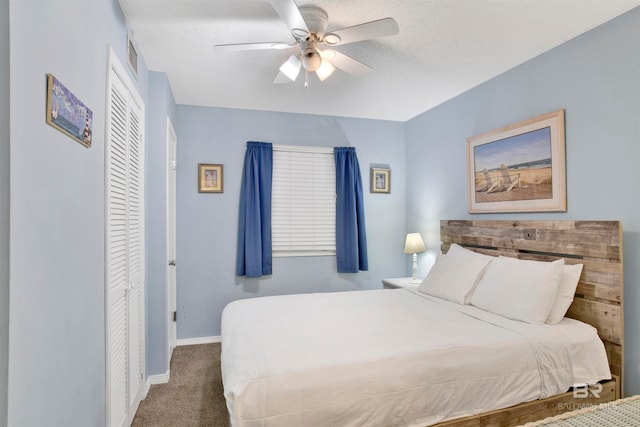 carpeted bedroom with a textured ceiling, ceiling fan, and a closet