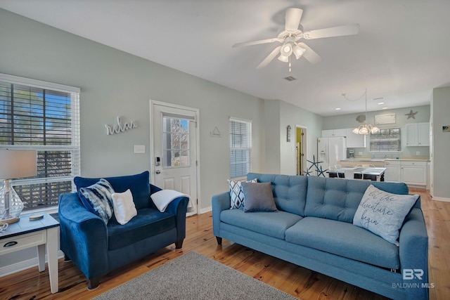 living room featuring light wood finished floors, a wealth of natural light, and a ceiling fan