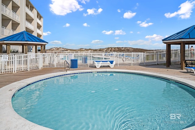 view of swimming pool with a gazebo and a mountain view