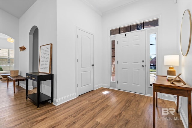 entryway featuring ornamental molding, a healthy amount of sunlight, and hardwood / wood-style flooring