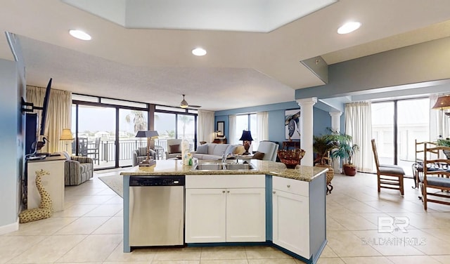 29235 Perdido Beach Blvd Unit 203, Orange Beach, AL 36561 - kitchen with stainless steel dishwasher, open floor plan, decorative columns, an island with sink, and white cabinetry