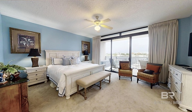 29235 Perdido Beach Blvd Unit 203, Orange Beach, AL 36561 - bedroom featuring access to exterior, light carpet, expansive windows, a textured ceiling, and a ceiling fan